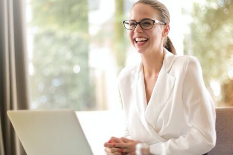 Executive Summary - Laughing businesswoman working in office with laptop